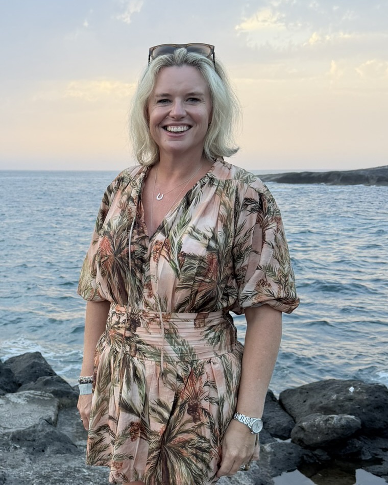 Erica from Virtual EA smiling on a coastline at sunset
